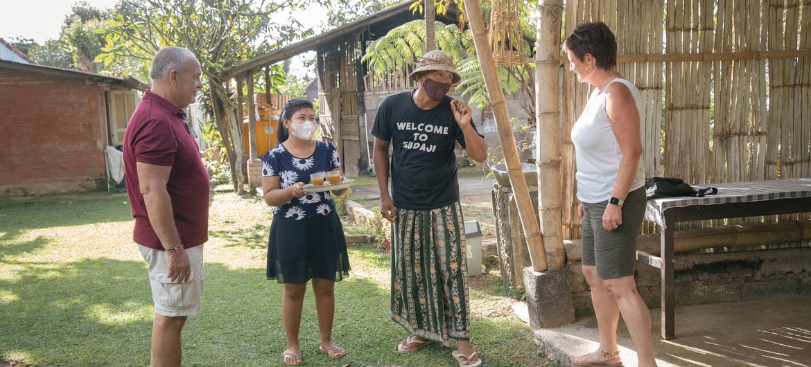 Dekha Dewandana and his wife greet their guests with traditional turmeric drink at Esa di Kubu Homestay in Sudaji Village, Buleleng, Bali, Indonesia.